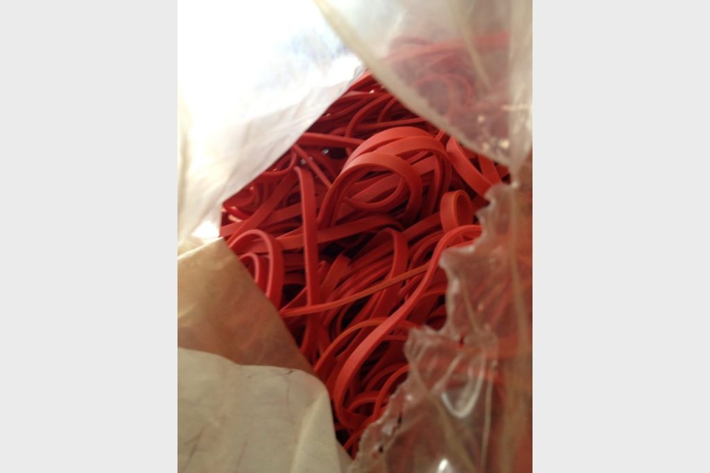 Red elastics were essential to the process. Luckily, Managing Editor Diane Mulligan found a huge bag of them in an office drawer. Photo by: Kristina England